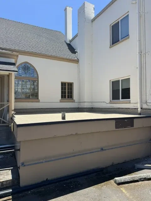 Low-slope roof surface beside a multi-story building