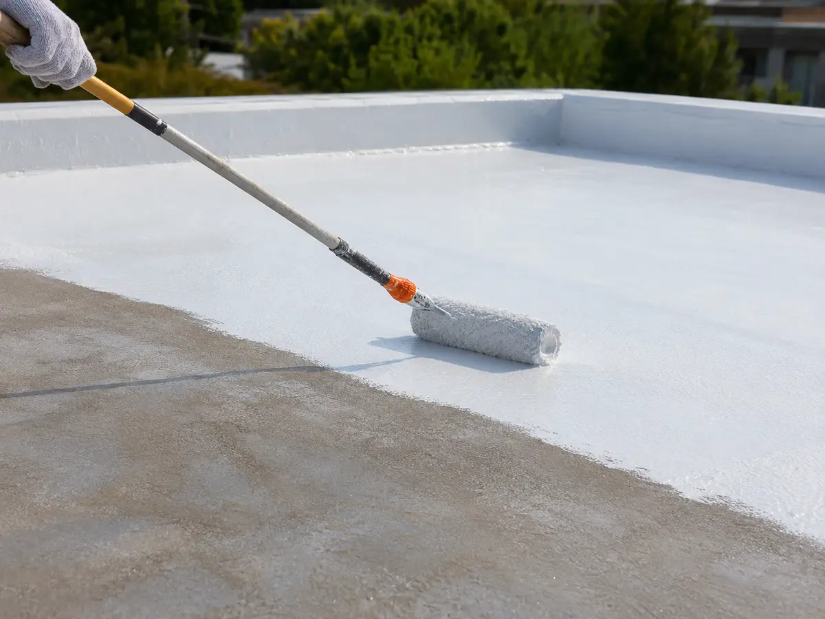 White roof coating being applied to a flat roof surface
